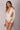 Side view of a model wearing a Lonarc one-piece long sleeve color Nude